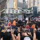 Protesters on Sunday, June 16, hold up photos of a man who was injured by the police.